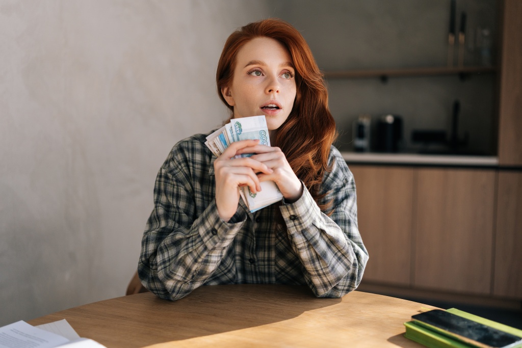 vertical-shot-unhappy-young-woman-holding-banknotes-feeling-stress-about-unemployment-home.jpg девушка