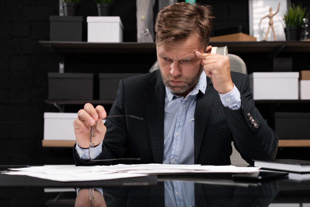 businessman-sitting-computer-desk-thinking-about-documents.jpg напряжение